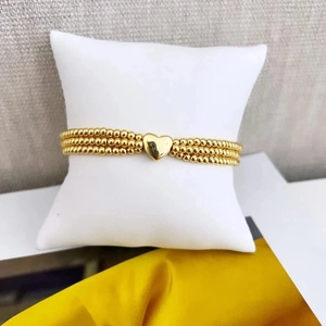 Three-layer 18K gold plated beaded bracelet featuring a polished heart pendant on white pillow