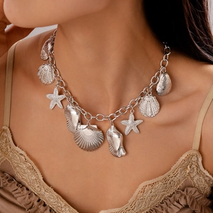 Macro shot of silver seashell and starfish necklace pendants on a stylish metal chain