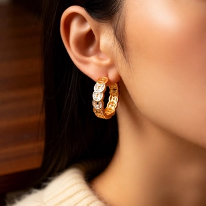 Detail of 18K gold-plated coin earrings with sparkling zircons worn by a model