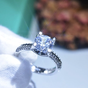 Macro shot of a D-color moissanite ring with brilliant starfire effect on white gloves