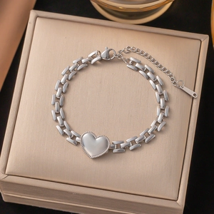 Silver heart pendant link bracelet with rectangular chain on light gold gift box lid