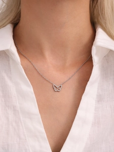 Close-up of a silver butterfly necklace with zircon stones on a model's neck