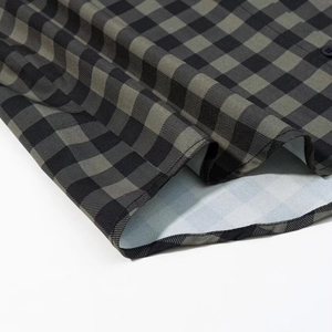 Close-up of black and green checkerboard shirt hem with detailed single needle stitching