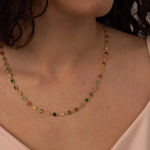 Close-up of elegant gold chain necklace featuring vibrant square multi-colored gemstones