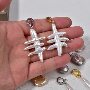 Handheld irregular baroque pearl earrings with silver and gold diamond-encrusted clasps
