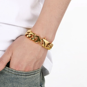 Detail of 18mm gold plated stainless steel Cuban link bracelet worn on male wrist
