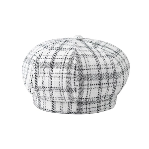 Close-up of black and white checkered tweed fabric and button detail on newsboy cap
