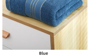 Detailed view of dark blue cotton bath towel with three elegant gold stripes