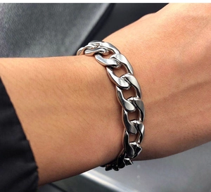 Detailed close-up of a silver polished stainless steel curb link chain bracelet on wrist