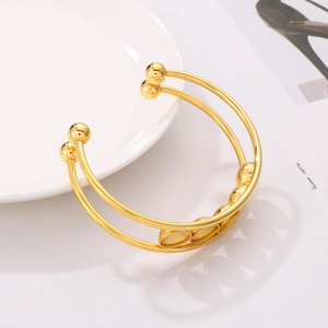 Close-up of golden double-layer titanium steel bracelet with polished circular settings