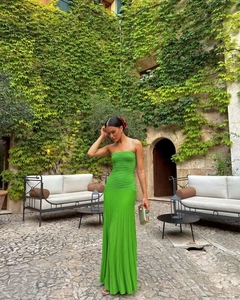 Detail view of a vibrant green pleated tube maxi dress with textured vertical fabric