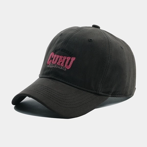 Detailed view of pink letter embroidery on black cotton twill baseball cap fabric