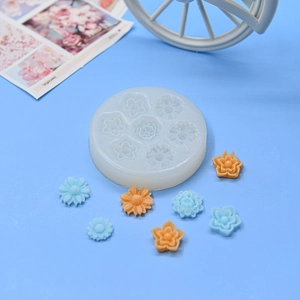Macro shot of 7-hole daisy silicone mold with resin flower crafts on blue background