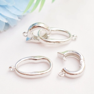 Detailed macro view of silver-plated 14K heart-shaped jewelry clasps on fabric