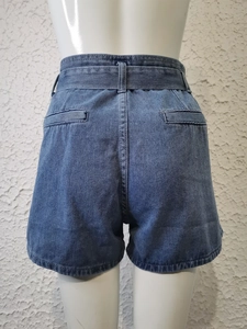 Dettaglio degli shorts in denim blu a vita alta con tasche posteriori su un manichino