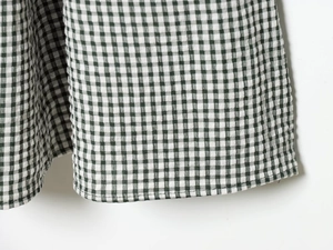 Gros plan du tissu à carreaux vert et blanc avec des détails de couture précis