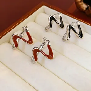 Orecchini a perno in argento a forma di S con finitura in smalto arancione e nero lucido