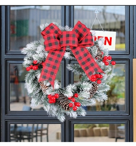 Detailed view of Christmas wreath with buffalo plaid bow, pine cones and red berries