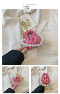 Close-up of rose pink pleated mini handbag with pearl handle and golden chain strap