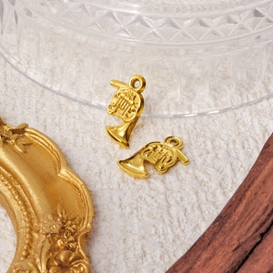 Pair of gold 304 stainless steel french horn pendants on a textured vintage background