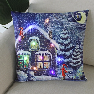 Detail of Christmas LED pillow cover with snowman and glowing lights on a beige sofa
