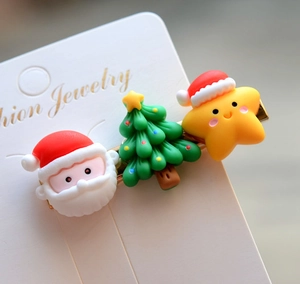 Detail of Christmas hair clips featuring Santa, tree and star icons on jewelry card