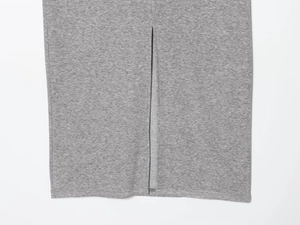 Detail view of the gray knit skirt hem showing clean stitching and central split design