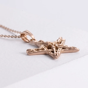 Close-up of rose gold punk star skull pendant showing metallic texture and details