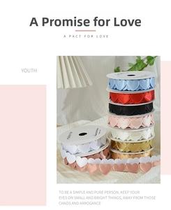 Close-up of heart-shaped satin ribbons in multiple colors on white round reels