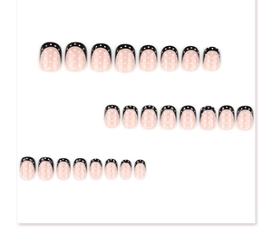 Detail showing 24pcs short round press-on nails with white polka dots and black French tips