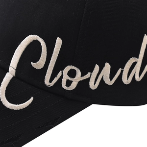 Close-up of white 3D Cloud embroidery on black cotton twill baseball cap fabric