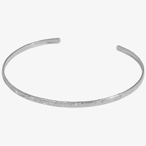 Detail view of silver open cuff bracelet showing irregular textured hammer finish metal