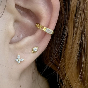 Macro shot of gold ear cuff and butterfly stud set with clear cubic zirconia on ear