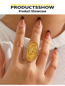 Detailed view of wide gold oval ring with intricate spiral texture on model finger