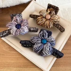 Winter knitted flower hair claw clips in purple, brown, and navy blue with pearl accents