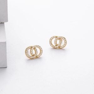 Detail of elegant gold double-loop earrings set with sparkling white cubic zirconia