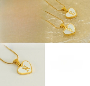 Detailed macro view of heart-shaped stainless steel necklaces with shell inlay and mirror finish
