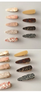Macro shot of acetic acid hair clips showing marble patterns and gold French branding