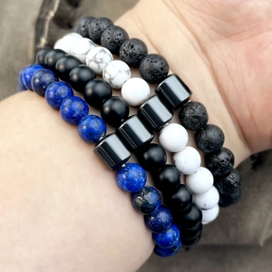 Close-up of beaded bracelets set featuring obsidian, turquoise, and lapis lazuli on wrist