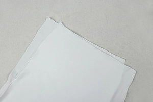 Gros plan sur la texture du tissu soyeux blanc avec un éclat lisse et drapé élégant