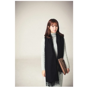 Detailed view of the long fringe tassels on a black solid cashmere-like winter scarf