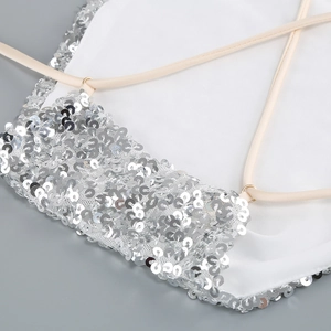 Detailed close-up of shimmering silver sequins and thin straps on an elegant evening gown