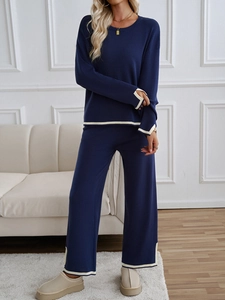 Navy knit set with beige trim details on sleeves and pants shown in an indoor setting