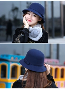 Dettaglio cappello in feltro blu scuro con fiocco e sciarpa di peluche grigia
