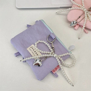 Detail of purple nylon card holder with pearl bow, heart pendant and SOZAKK label