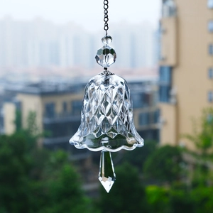 Detail shot of a bell-shaped faceted crystal suncatcher with a diamond-shaped pendant