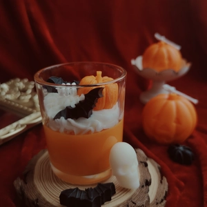 Detailed view of Halloween soy wax candle with mini 3D pumpkins and bats in a glass cup