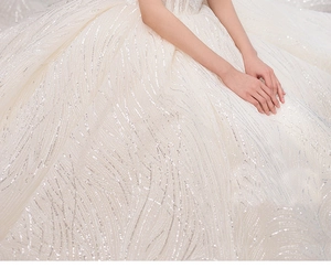 Detail of starry sequin embroidery on bridal gown featuring elegant wave patterns