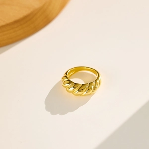 Macro view of gold croissant ring showing sleek spiral texture and polished finish