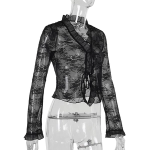 Détail du tissu en dentelle noire transparente et des bordures festonnées aux manches